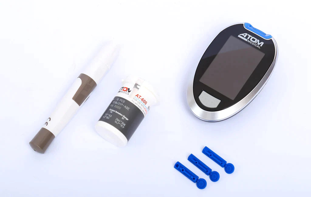 Atom AT 600 glucometer with accessories including test strips, lancets and lancing device.